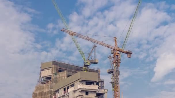 Grues travaillant sur des travaux modernes de chantier de construction de nouveaux gratte-ciel timelapse — Video