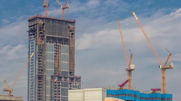 Gru che lavorano a lavori di cantiere di vincolo moderni di nuovo timelapse di grattacielo — Video Stock