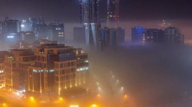 Binalar Business Bay 'de gece vakti yoğun sis tabakasıyla kaplıdır..