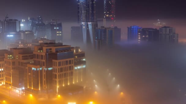 Los edificios están cubiertos de una gruesa capa de niebla en el timelapse nocturno de Business Bay. — Vídeos de Stock