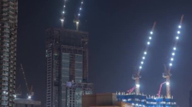 Yeni gökdelenlerin modern soyutlama sahaları üzerinde çalışan turnalar gece zaman çizelgesi