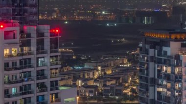 Kanal yakınındaki lüks evler ve villalar. Kuleleri olan gökdelenler. Business Bay, Dubai, Birleşik Arap Emirlikleri 'nde gece saatleri..