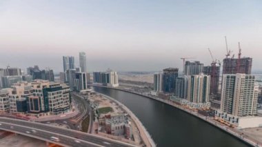 Business Bay hava sahasındaki gökdelenler Dubai, Birleşik Arap Emirlikleri 'ndeki gece ve gündüz saatleri.