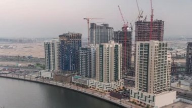 Dubai, Birleşik Arap Emirlikleri 'ndeki Business Bay hava sahasında günden geceye kadar kuleler.