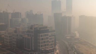 Gündoğumunda Business Bay bölgesinde modern şehir mimarisi. Dubais gökdelenlerinin panoramik görüntüsü sisli sabah zamanı