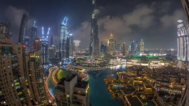 Небоскрёбы, возвышающиеся над центром Дубая ночью в окружении современных зданий — стоковое видео