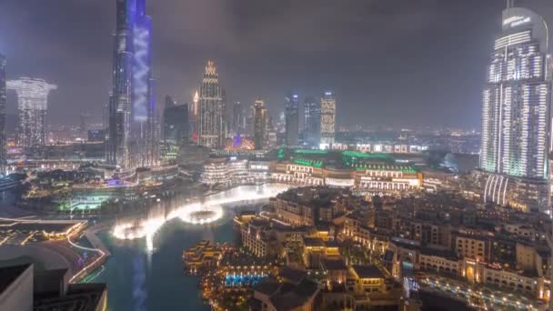 A Dubai belvárosa fölé emelkedő felhőkarcolók éjszakai időintervalluma modern épületekkel körülvéve — Stock videók