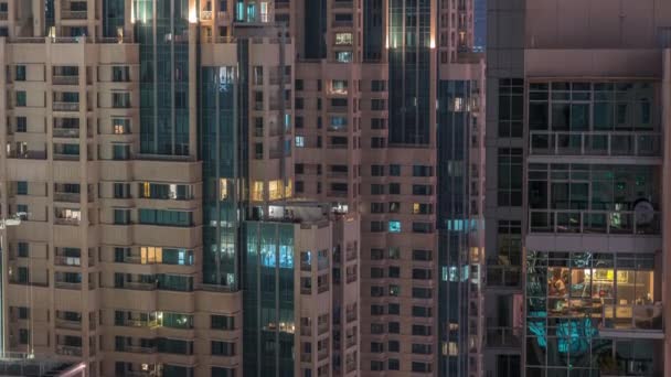 Okna ve výškovém exteriéru budovy v pozdních večerních hodinách s interiérovými světly — Stock video