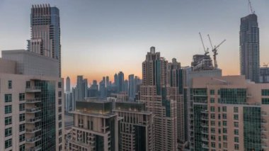 Dubai gökdelenleri iş sahasının üzerinde altından gökyüzü ile gündüz ve gece saatleri.