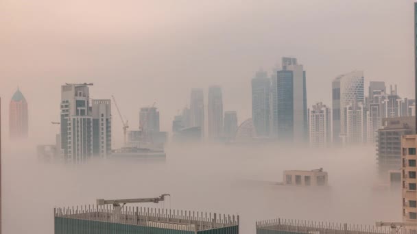 Дубайські хмарочоси, вкриті ранковим туманом в діловому районі бухти під час сходу сонця.. — стокове відео