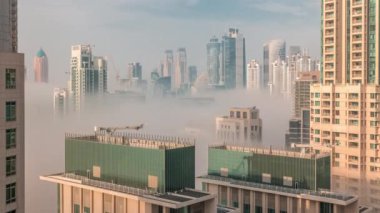 Dubai 'deki gökdelenler, güneş doğarken iş sahasında sisle kaplıydı..