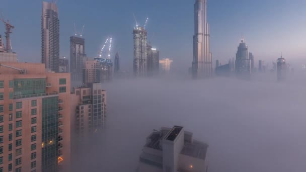 Vista aérea de la ciudad de Dubai temprano en la mañana durante la niebla noche al día timelapse. — Vídeos de Stock