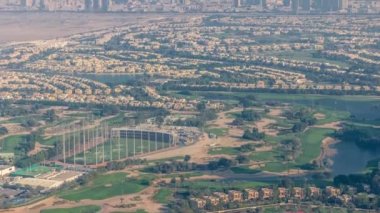 Yeşil çimenli, göllü, villalı ve evlerin olduğu golf sahasına hava manzarası zaman ayarlı..