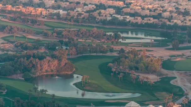 Luftfoto til Golfbane med grøn græsplæne og søer, villaer og huse bag det timelapse. – Stock-video