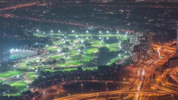 Lucht uitzicht op golfbaan met groen gazon en meren, villa 's en huizen achter het nachtelijk tijdsbestek. — Stockvideo