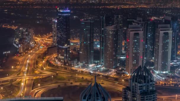 Rascacielos JLT y Dubai marina cerca de Sheikh Zayed Road aérea toda la noche timelapse. Edificios residenciales — Vídeos de Stock