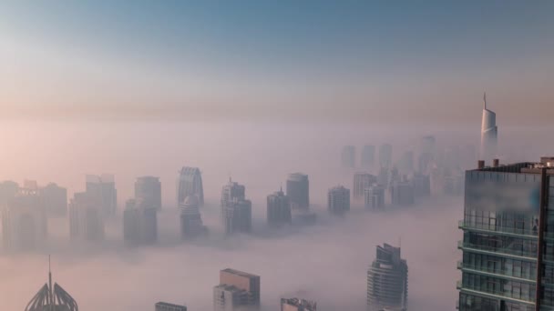 Tåge dækkede JLT skyskrabere og marinatårne nær Sheikh Zayed Road luftfoto efter solopgang. Boligbyggeri – Stock-video