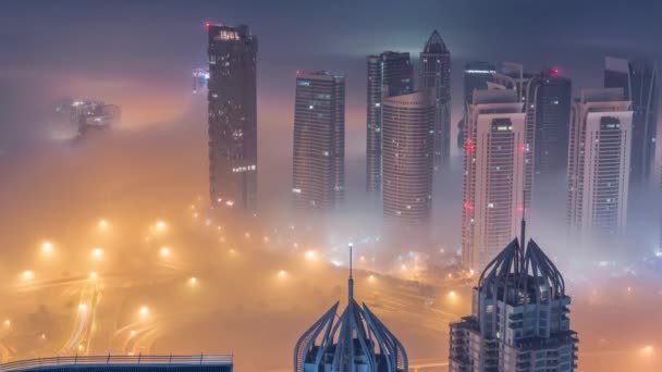 Rascacielos JLT cerca de Sheikh Zayed Road de noche aérea al día timelapse. Edificios residenciales — Vídeos de Stock