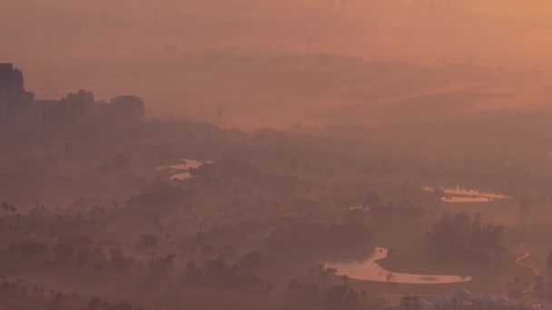 Vista aérea para Campo de golfe com gramado verde e lagos, moradias cobertas por nevoeiro matutino timelapse. — Vídeo de Stock