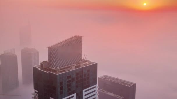 Rare early morning winter fog above the Dubai Marina skyline and skyscrapers lighted by sun aerial timelapse. — Stock Video