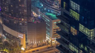 Dubai Medya Şehri 'nde geceleri parlayan mavi camlı modern binalar Birleşik Arap Emirlikleri