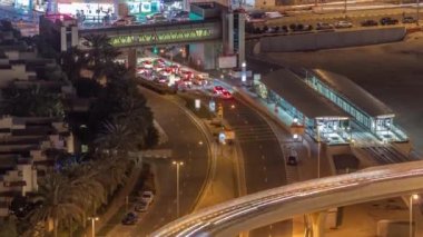 Dubai Marina 'daki tramvay istasyonunda yaya köprüsü havası gece zaman ayarlı.