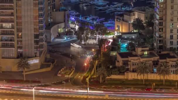 Vista aérea de una intersección de carreteras entre rascacielos en Dubai puerto deportivo noche timelapse. — Vídeos de Stock