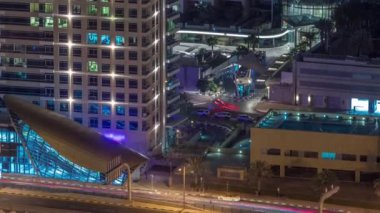 Metro istasyonundan çıkış ve gece vakti Dubai marinasında yol trafiği.
