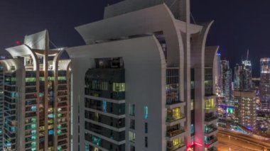 JLT ve Dubai marina gökdelenlerinin hava görüntüsü. Parlayan pencereleri olan. Gece vakti Sheikh zayed yolunda trafik vardı..
