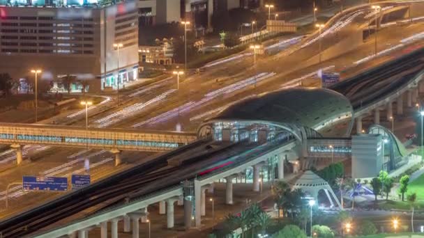 Estación de metro y tráfico en una autopista entre Dubai media city y campo de golf timelapse noche — Vídeos de Stock