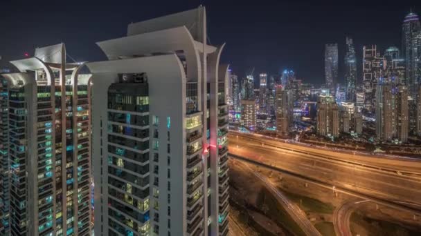 Vista aerea del porto turistico di Dubai e grattacieli JLT con finestre luminose timelapse notte con traffico su strada Sheikh zayed. — Video Stock