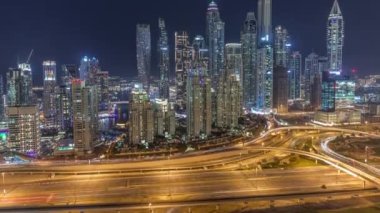 Dubai Marina 'nın gökdelenleri Sheikh Zayed Yolu' nun kesiştiği yerde gece yüksek konut binaları var.