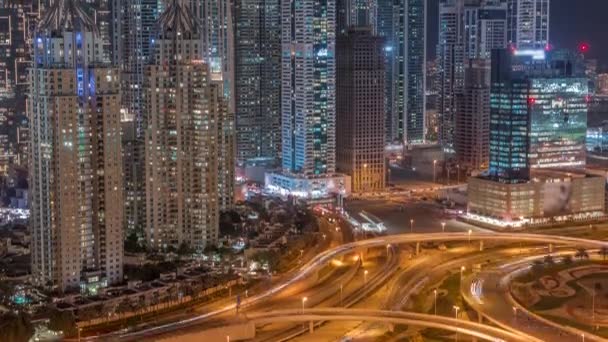 Vista aérea de Dubai Marina con gran cruce de carreteras noche timelapse y rascacielos alrededor, Emiratos Árabes Unidos — Vídeos de Stock