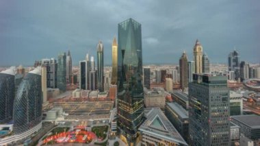 Dubai 'deki finans bölgesi iş merkezindeki fütüristik gökdelenlerin panoraması gece gündüz