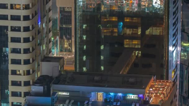 Piscina en la azotea vista desde arriba por la noche timelapse, vista aérea en el distrito financiero. Gente relajada. Dubai, Emiratos Árabes Unidos — Vídeo de stock