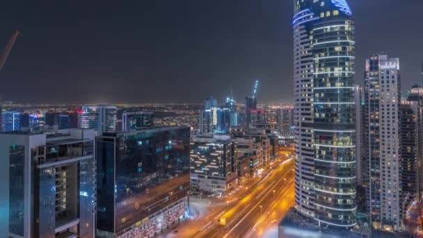 Dubais business bay towers aerial night timelapse. Rooftop view of some skyscrapers — Stock Video