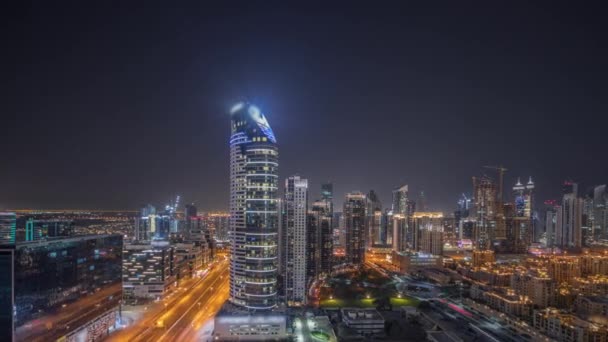 Panorama menunjukkan Dubais menara teluk bisnis malam udara timelapse. Atap tampilan dari beberapa pencakar langit — Stok Video