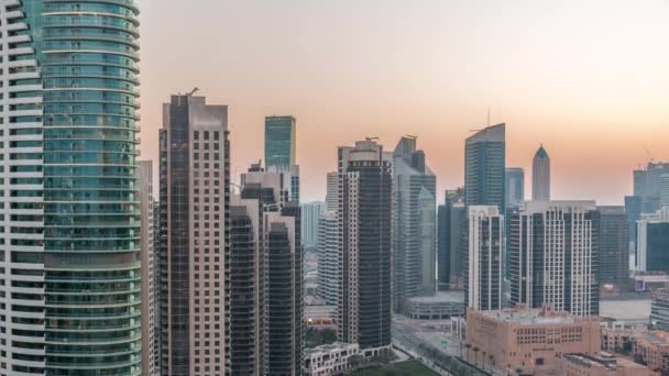 Dubais business bay torri aeree giorno alla notte timelapse. Vista sul tetto di alcuni grattacieli — Video Stock