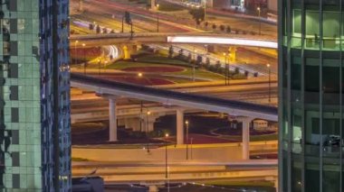 Dubai şehir merkezindeki gece trafiğinde büyük kesişen araçların hava görüntüsü.