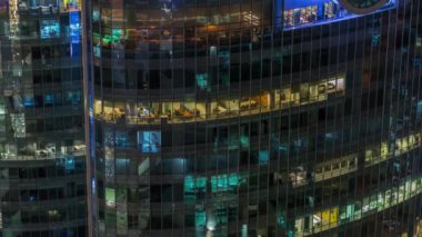 Modern ofiste büyük parlayan pencereler ve gece vakti konut binaları.