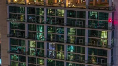 Modern ofiste büyük parlayan pencereler ve gece vakti konut binaları.