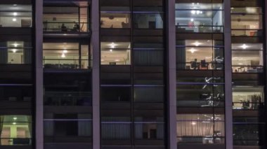 Modern ofiste büyük parlayan pencereler ve gece vakti konut binaları.