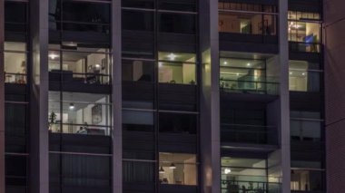 Modern ofiste büyük parlayan pencereler ve gece vakti konut binaları.