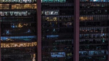 Modern ofiste büyük parlayan pencereler ve gece vakti konut binaları.