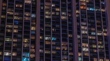 Modern ofiste büyük parlayan pencereler ve gece vakti konut binaları.