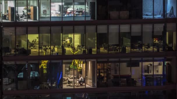 Большие светящиеся окна в современных офисных зданиях по ночам — стоковое видео