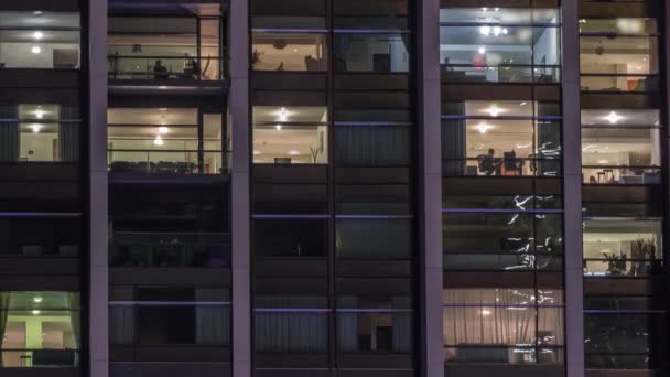 Великі сяючі вікна в сучасних офісних та житлових будівлях вночі — стокове відео