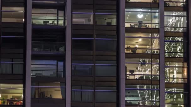 Grandes janelas brilhantes em escritórios modernos e edifícios residenciais timelapse à noite — Vídeo de Stock