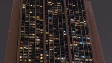 Modern ofiste büyük parlayan pencereler ve gece vakti konut binaları.