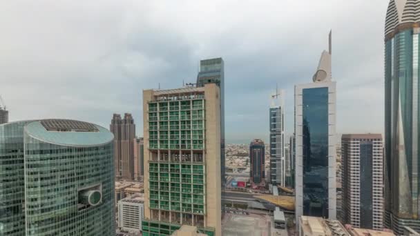 Panorama que muestra los rascacielos del centro financiero internacional de Dubai con paseo marítimo en un timelapse aéreo de la avenida de la puerta. — Vídeos de Stock